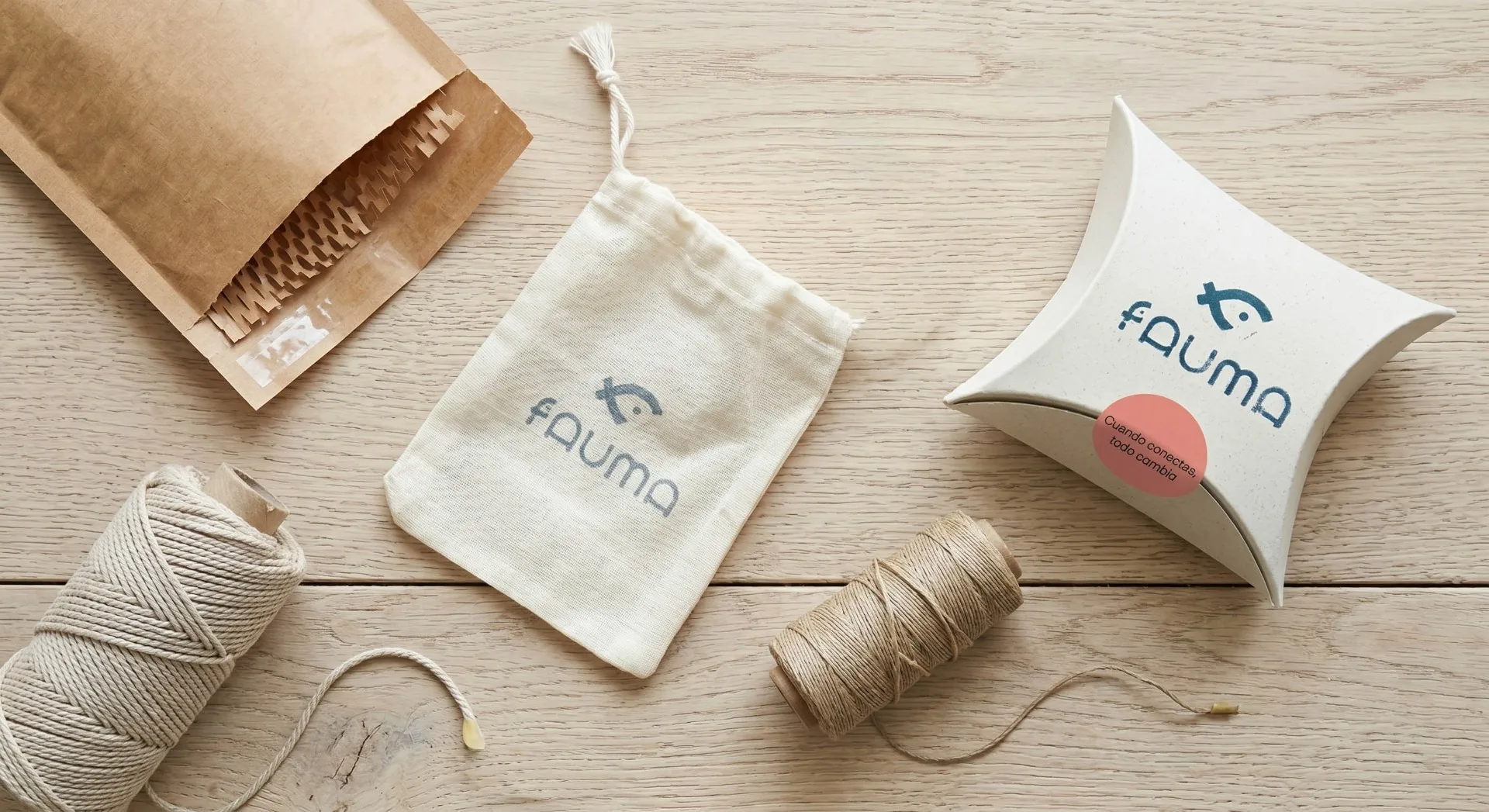 Packaging Fauma sobre mesa de madera con bolsa de tela y caja