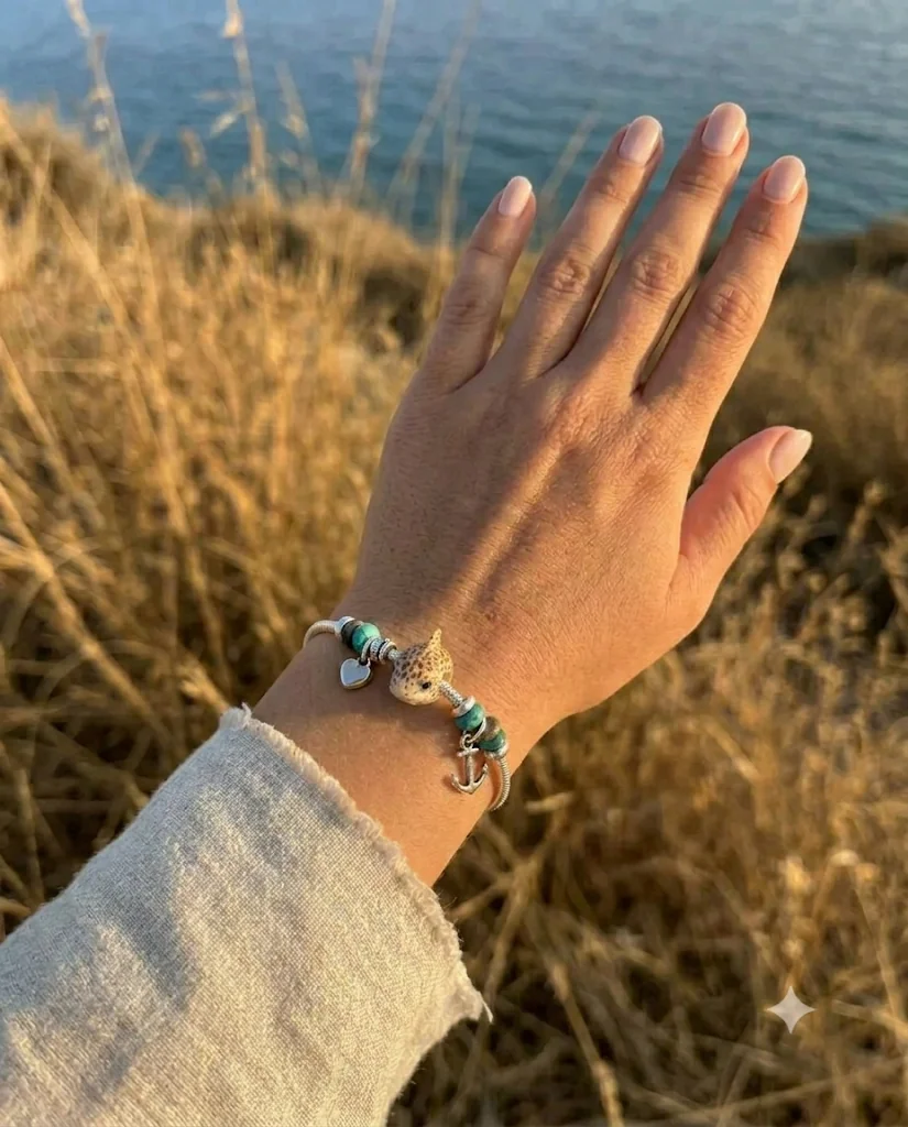 Pulsera Fauma con charms sobre la muñeca al atardecer
